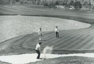 On the beach, Club pro Bobby Breen tests sand traps on final hole at Glen Abbey golf course near Oakville