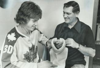His neck scarred by skate cut that severed his jugular vein,-18-year-old Kim Crouch approves the neck protector designed by his father, Whitby Fire Ch(...)