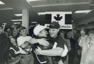 Winning smile: Goalle Manny Legace, left, who helped Canada to world Junior hockey title, is hugged by brother Chris at Pearson International Airport