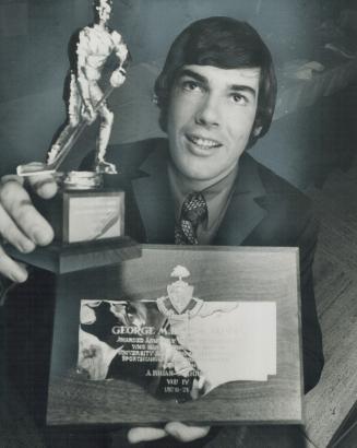 Double winner: Brian St. John of hockey Blues displays George M. Biggs Trophy, Varsity's top athletic award, and Dr. Bill Dafoe Trophy, hockey honor