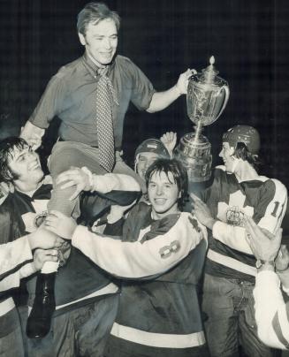 George Armstrong, coach of Marlboros, is raised in triumph by his players, headed by Bruce Boudreau (8), after team tied Peterborough Petes, 5-5, Satu(...)