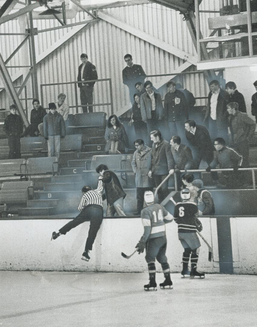 Referee Strikes Back, Leaping high off the ice, referee Bob Fryday throws a solid punch at an obstreperous fan yesterday during collegiate league game(...)