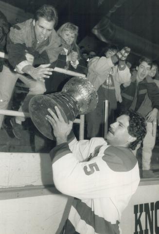 Hoisting it high: York strongman Dave Andreoli raises the University Cup before boisterous fans at Varsity Arena after the Yeomen captured their second hockey title in four years