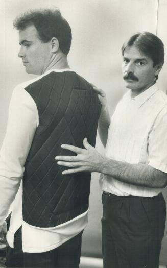 No more welts? Inventor James Croteau, right, demonstrates his new Blue Armadillo Padded shirt on Star reporter Damien Cox. The shirt will protect hockey players from back injuries
