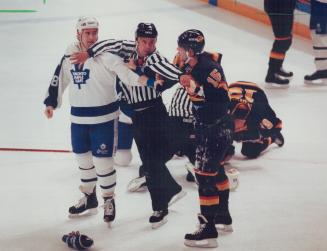 A linesman intervenes in a second-period altercation between Maple Leaf rightwinger Kevin Maguire and Vancouver Canucks defenceman Adrien Plavsic. The(...)