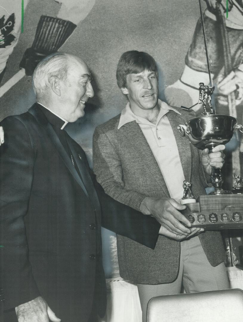 Charity champ: St. Louis Blues' Ed Kea brandishes the trophy he received at the Conacher dinner last night as Emmett Cardinal Carter admires the award and the winner