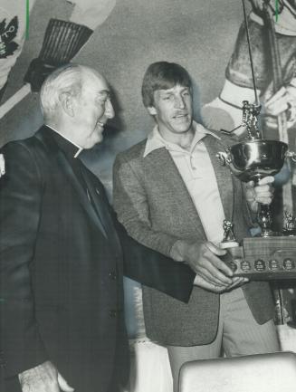 Charity champ: St. Louis Blues' Ed Kea brandishes the trophy he received at the Conacher dinner last night as Emmett Cardinal Carter admires the award and the winner
