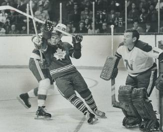 Move along now!, Maple Leafs' Paul Henderson, caught loitering in Minnesota goalcrease, is hustled out of there by North Stars' Marshall Johnston, pla(...)