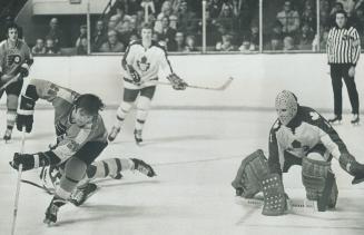 Nifty Manoeuvre is executed by Jim Johnson (20) of Philadelphia Flyers as he eludes sprawling defenceman Brian Glennie (24) to get stick on puck for s(...)