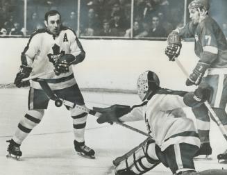 A grimace appears on the face of Toronto Maple Leaf defenceman Bob Baun as goaltender Jacques Plante bats the puck out of the air with his stick as De(...)