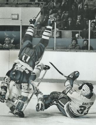 What goes up ? Minnesota Fighting Saints' Frank Huck (25) heads for hard landing on Maple Leaf Gardens' ice after collision with Toros' Jim Turkiewicz(...)