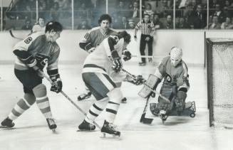A Narrow Miss: Goalie Wayne Stephenson of Philadelphia Flyers traps puck neatly to foil scoring Harast by Leafs' Darryl Sittler during National Hockey League game at the Gardens last night