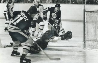Bruins' Bobby Schmautz (11) and Stan Jonathan (17) get set for rebound off a sprawling Paul Harrison