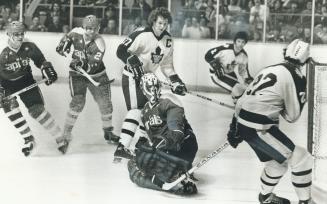 Cap goalie Gary Smith escaped this scoring thrust by Darryl Sittler (27) and Dave Williams