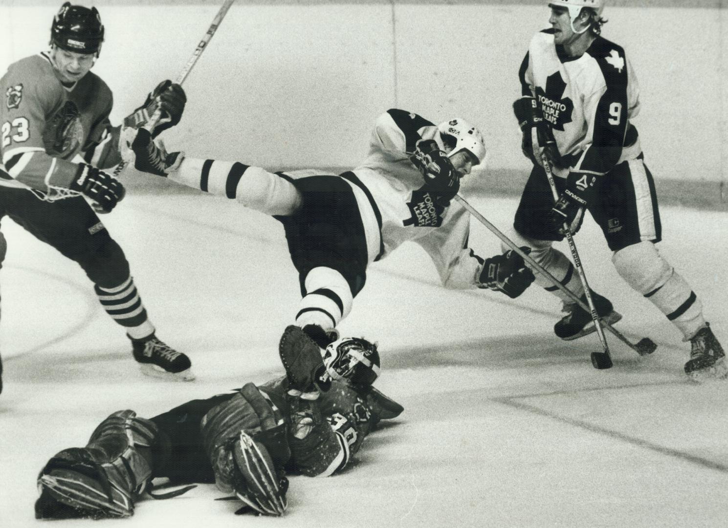 A flying Leaf, Hard-working Greg Terrion flies over Chicago goalie Murray Bannerman while trying to poke the puck into the net during last night's gam(...)