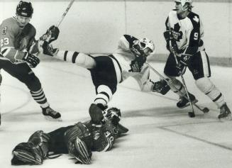 A flying Leaf, Hard-working Greg Terrion flies over Chicago goalie Murray Bannerman while trying to poke the puck into the net during last night's gam(...)