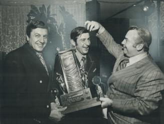 Now look pretty. Lou Janetta, president of the Canadian-Italian Hockey League, moves to straighten the hair of Ralph Ruffo, the league's most valuable(...)