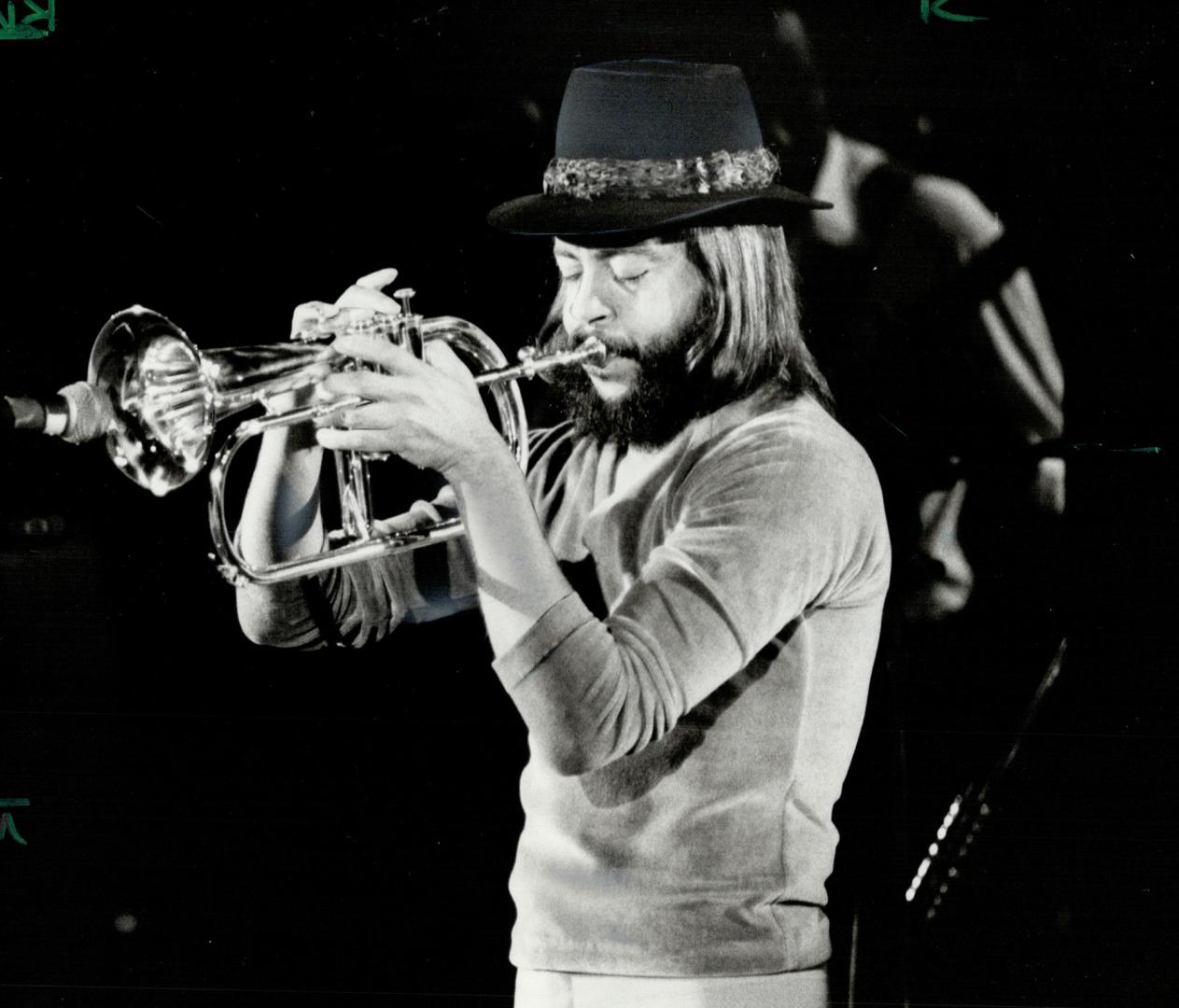 Playing it cool. Chuck Mangione, eyes closed in concentration, caresses the microphone with golden notes from his flugelhorn at the Ontario Place Foru(...)