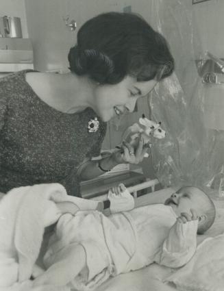 Learning at first hand. Controller June Marks takes a moment out to play with three-month-old Susan Shaw during a visit to the physiotherapy departmen(...)