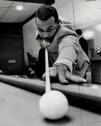 Mann takes aim. Argo football player Dave Mann lines up a shot during opening of posh Embassy Billiards Lounge on Bloor St., W. last night. Too bad it(...)