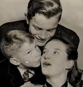 Member of the Canadian Army show, Lois Maxwell, being kissed by brother David, seven, as Keith looks on, stayed in London when the army show broke up (...)