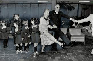 Ceremonial dance. Mayor Hazel McCallion and Lieutenant-Governor John Aird join with Brownies in Indian dance following the opening of exhibition of pa(...)