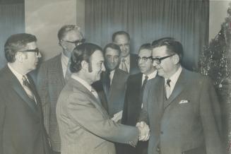 Dennis McDermott, Canadian director of the United Auto Workers, shakes hands with George Morris (right), director of labor relations for General Motor(...)