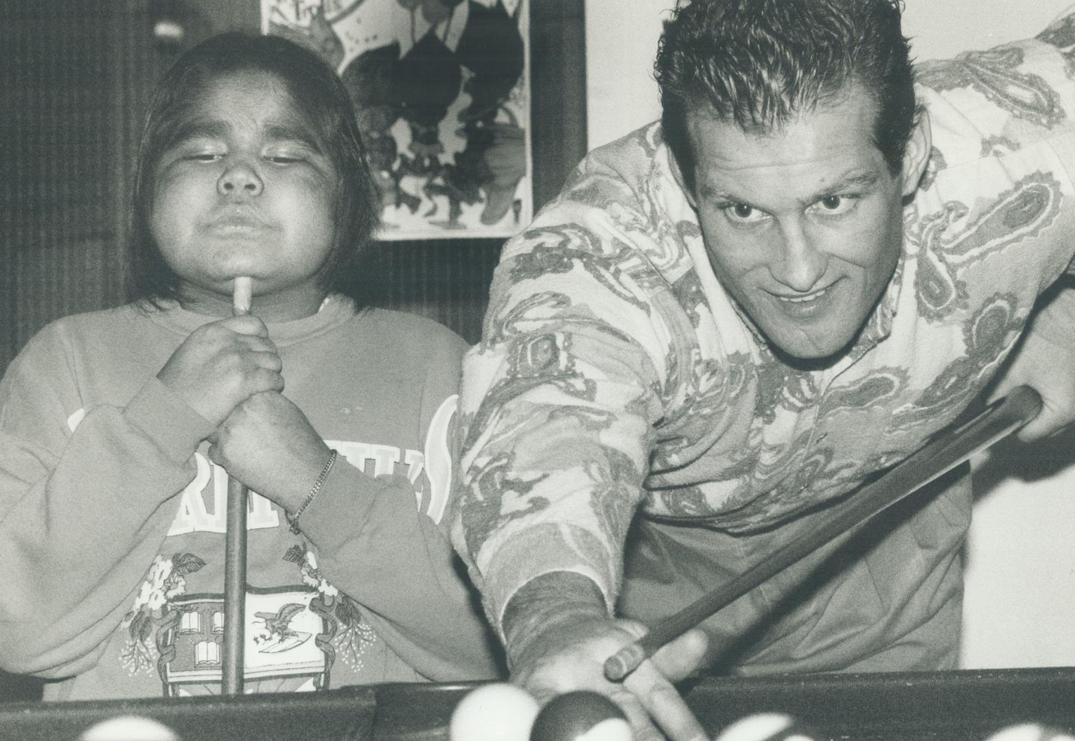 Spreading christmas cheer: Defenceman Bob McGill shoots a little pool with 8-year-old patient Denise Winter as several Maple Leafs paid a visit to the Hospital for Sick Children yesterday