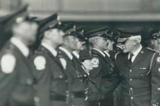 Eyes front - and up. Metro police Chief William McCormack inspects officers of the Auxiliary Police Force yesterday at Fort York Armories. Representat(...)