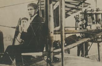 Photo of J. C. McCurdy in aeroplane equipped with wireless. J. McCurdy, aviator and an old time telegraph operator. Was successful in sending a wirele(...)