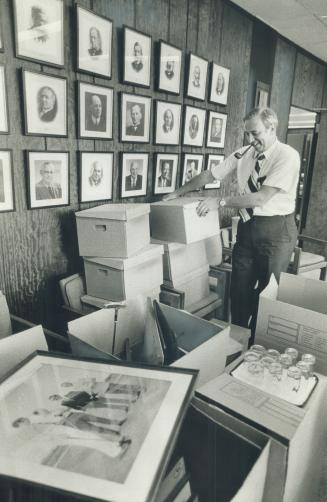 A smiling Darcy McKeough packs cartons as he prepares to clear out his office at Queen's Park