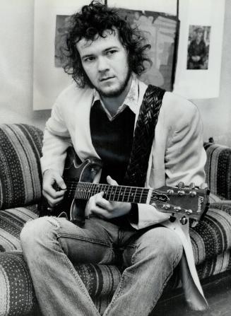 Strumming his $1,000 guitar in his flat above garage near Queen and Parliament is Toronto rock singer Murray McLauchlan