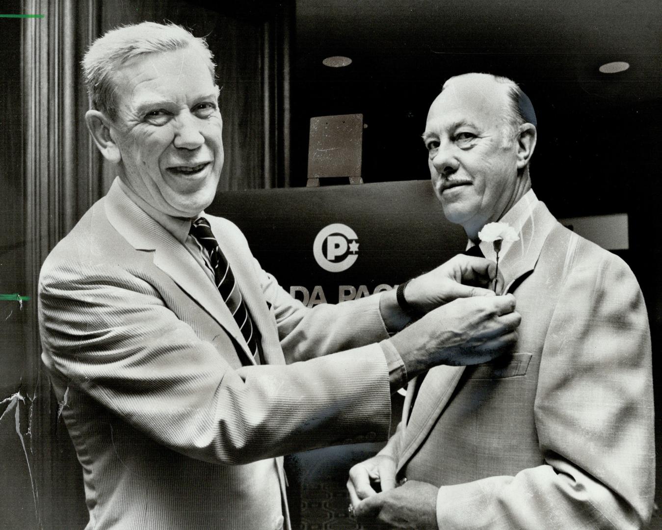 W. F. (Bill) McLean, president of Canada Packers Ltd., decorates George D. Mungall, his former executive vice president, with an impromptu carnation a(...)