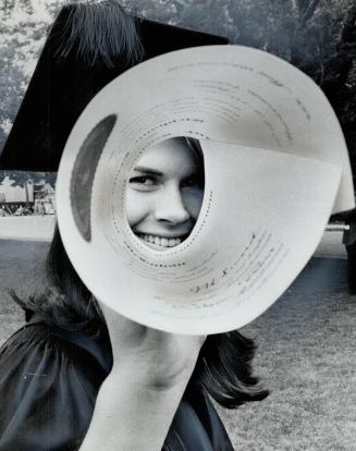 Peeking into the future through eyepiece made of her rolled-up diploma, Stephanie McLuhan, daughter of communications expert Marshall McLuhan, smiles (...)