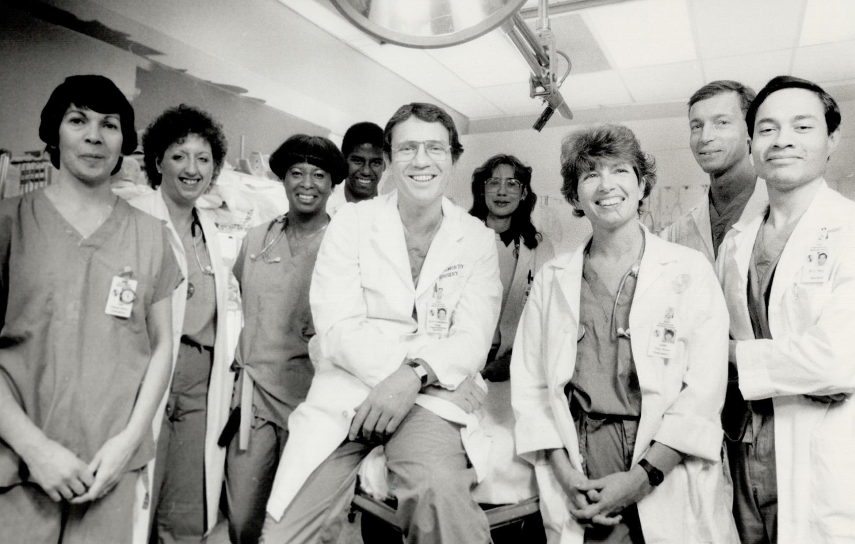 Dr. Robert McMurty, head of the trauma unit he co-founded, is flanked by some of his team
