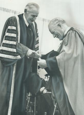 An honorary degree is confereed on Governor-General Roland Michener (right) by Chancellor of York University, Floyd Chalmers at a ceremony last night