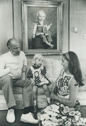 With her parents, Cara sits beneath her portrait painted by her father