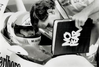 Rick Mears speaks with a member of his team who holds a binder with no fear written on it