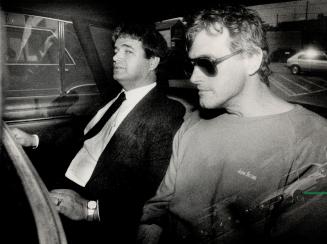 In custody: A handcuffed Frederick Rodney Merrill, right, is accompanied by Constable Robert Byrnes on his return to Toronto to face police investigation into rape charges