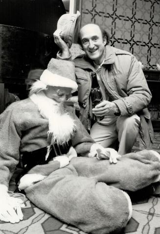 Below, actor Ron Moody checks in with a snoozing Santa