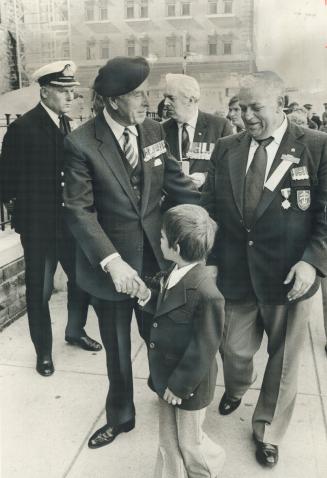 Earl Mountbatten of Burma shakes hands with Christopher Stevens and talks with his father, Bill Stevens (right) of Dieppe Veterans and Prisoners of Wa(...)
