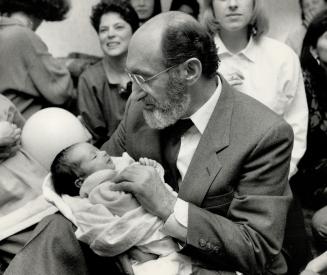 Cradling son: Dr. Henry Morgentaler holds his 2 1/2-week-old baby Benjamin at a victory party that followed yesterday's Supreme Court of Canada ruling(...)
