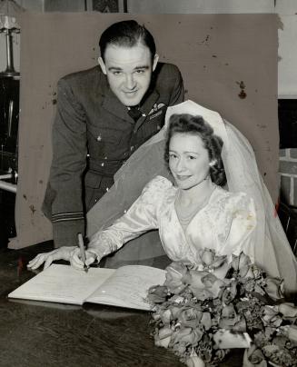 Flight-Lieut. Don Morrison, D.F.C., D.F.M., and his bride, formerly Miss Jean Griffin, are pictured at the signing of the marriage register after thei(...)