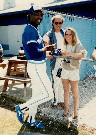 Added attraction: Lloyd Moseby signs autograph for fans visiting Toronto Blue Jays spring training base at Dunedin, Fla