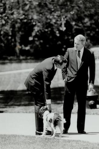 U.S. President George Bush pats his dog Millie as he and Brian Mulroney chat on the White House lawn