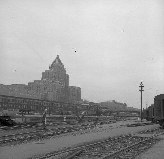 Looking north east from C.P.R. John St. roundhouse, across Toronto Terminal Railway yards. Royal York hotel in background. Toronto, Ontario