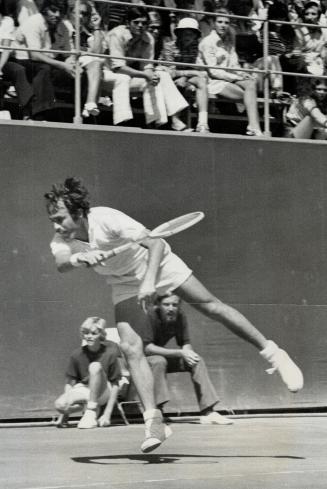 Power personified, Tennis ball takes a real beating from boomier service forehand smashes of Australian John Newcombe a he defeats Tom Olker of Nether(...)