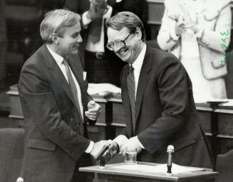 Congratulations from the boss, Premier David Peterson, left, shakes Treasurer Robert Nixon's hand after the reading of the budget in Legislature yeste(...)