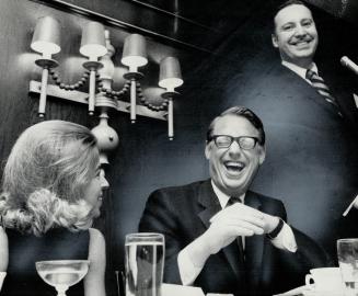 Laughing together, Mrs. Robert Stanbury, wife of the minister responsible for Information Canada, and Ontario Liberal Leader Robert Nixon listen to sp(...)
