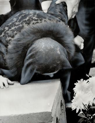 Sobbing at son's funeral, Mrs. Maria Nobrega leans forward to kiss the concrete outer vault in which the casket of 20-year-old Angelo Nobrega was buri(...)